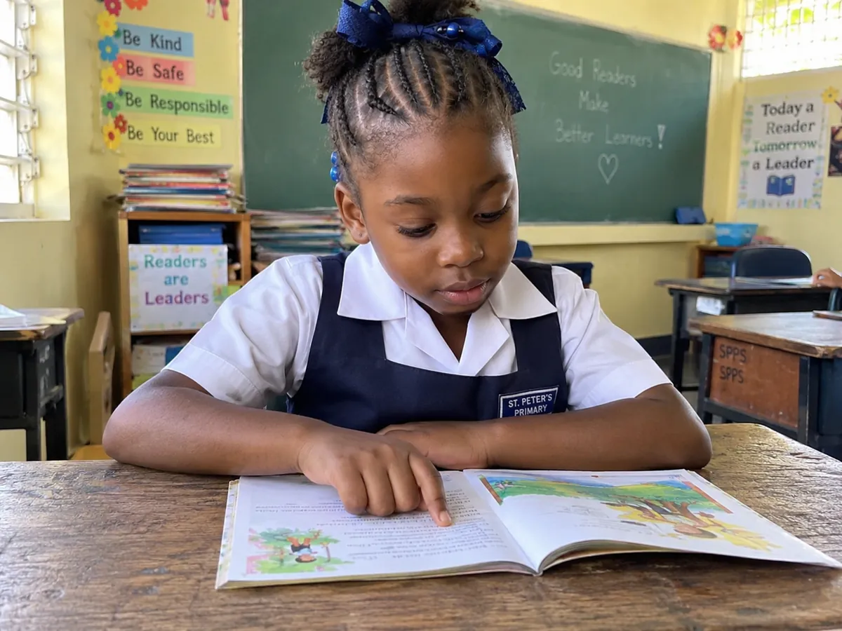 A Grade 2 girl reading a storybook at her desk